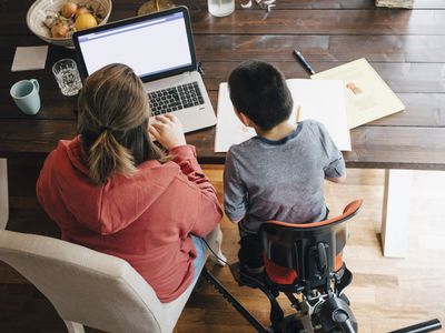 High angle view of mother with autistic son watching video on laptop while sitting at home
