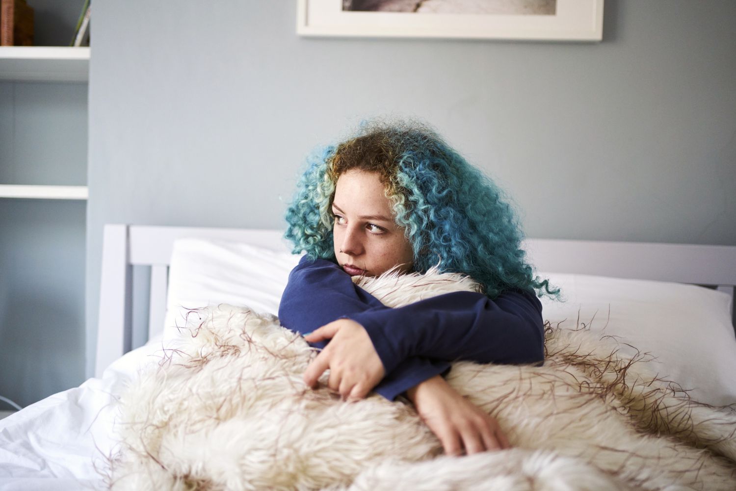 Young woman looking sad depressed and alone in bed