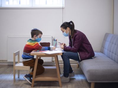 Six year old boy working with a psychologist at the psychotherapy session.