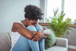 woman at home feeling ashamed and unhappy