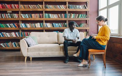 Young Black man talks with a female therapist