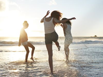 Young women hanging out at the beach, at sunset