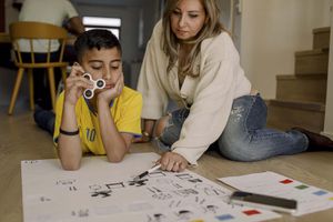Mother teaching son while sitting at home