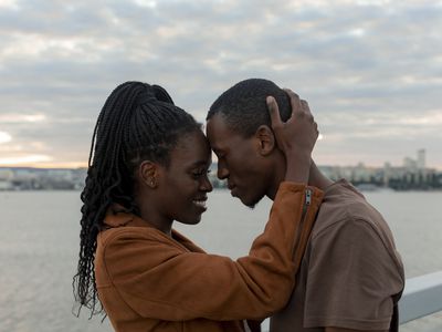 Black couple embracing forehead to forehead on the beach